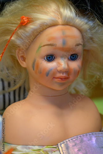 Plastic face painting bust with blonde hair.