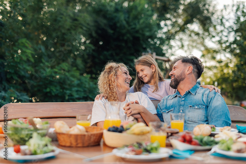 Photography Happy family enjoying backyard meal together