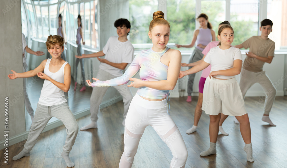 Naklejka premium Group of boys and girls rehearsing jazz funk dance in studio