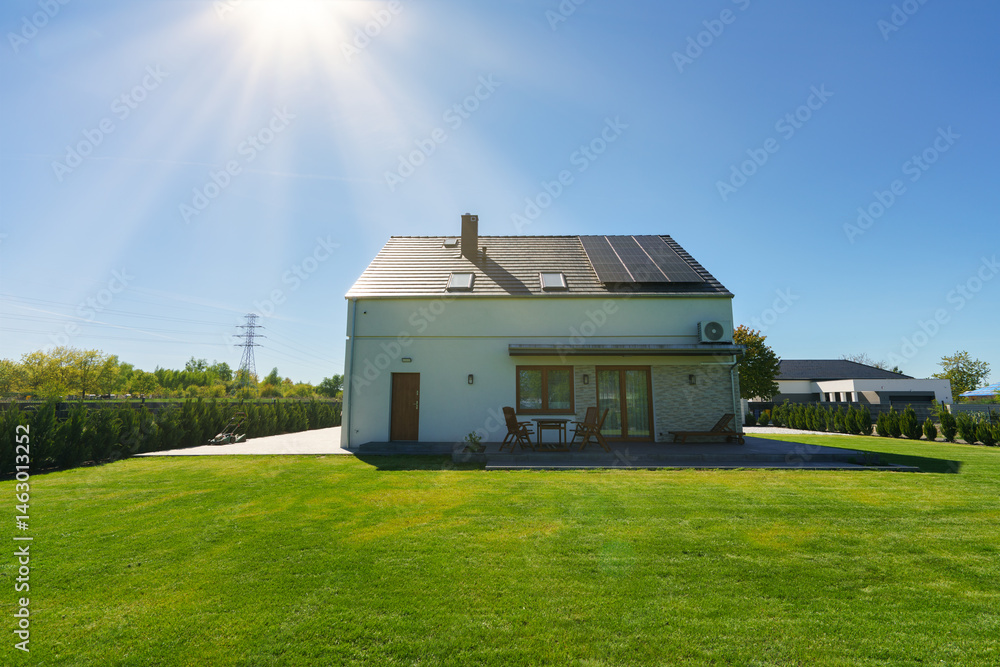 New build fully detached house with solar panels under sunlight beams