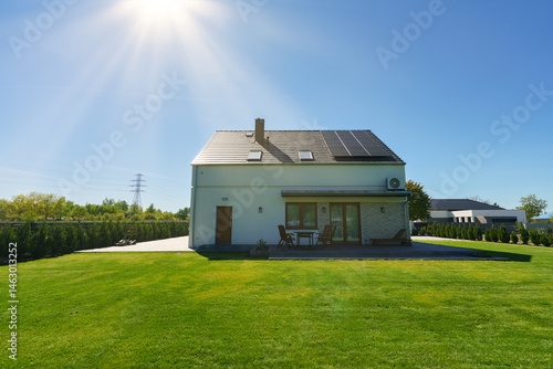 Obraz na płótnie New build fully detached house with solar panels under sunlight beams w salonie