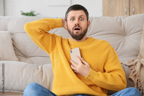 Shocked young man using mob...