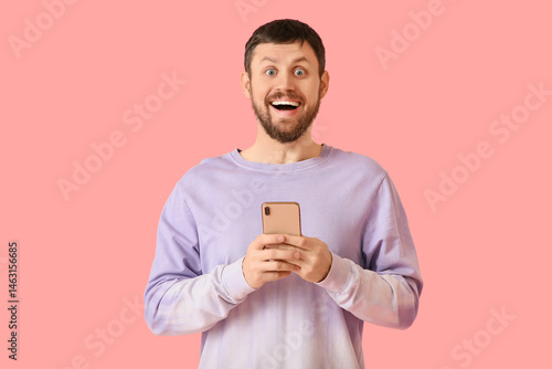 Surprised young man using m...