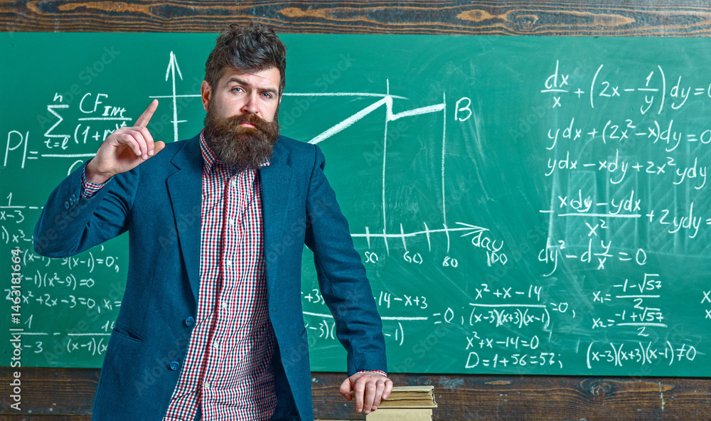 Teacher explains math in class. Professor in classroom on math lesson. University professor writes math formula. Bearded teacher. Professor teaching lesson in classroom. Professor explains math.
