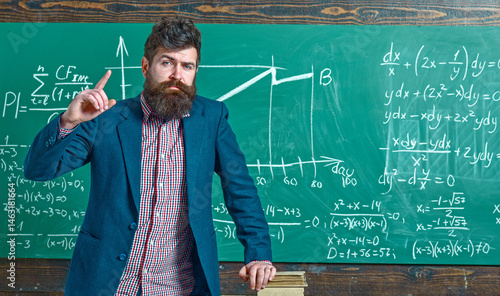 Obraz na płótnie Teacher explains math in class. Professor in classroom on math lesson. University professor writes math formula. Bearded teacher. Professor teaching lesson in classroom. Professor explains math. w salonie