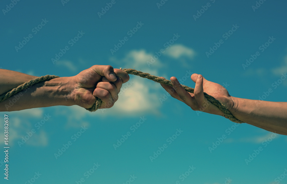 Conflict or tug. Two hands, helping hand, arm, friendship. Rope, cord. Hand holding a rope, climbing rope, strength and determination. Rescue, help, helping gesture hands. Helping hand support concept