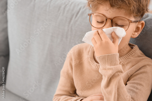 Sick little boy with tissue...