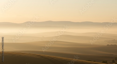 Misty Sunrise Over Rolling Hills and Distant Mountains