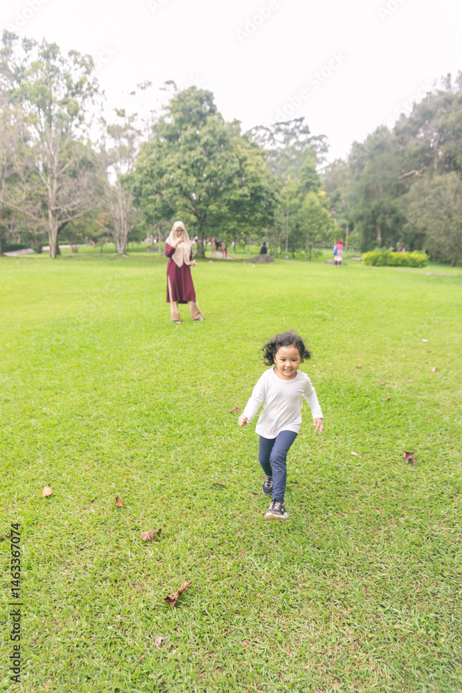 Fototapeta premium Mother with little daugher is playing in an outdoor park