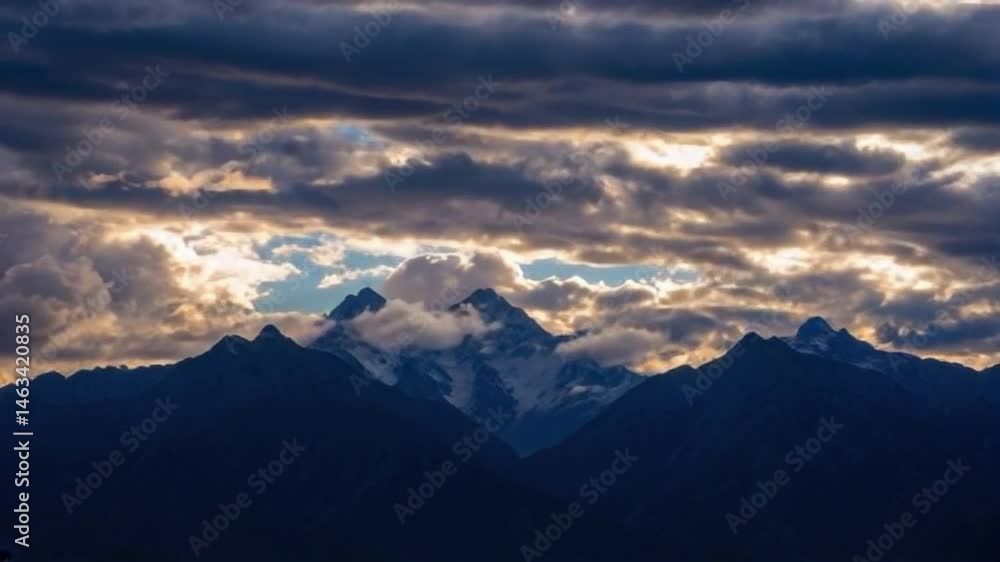 Sunlight Illuminates Mountain Peaks as Clouds Roll Across Sky Sunlight Illuminates Mountain Peaks as Clouds Roll Across Sky