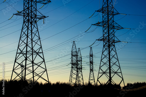 Looking up steel power pylon construction with high voltage cables against blue sky. Banner for electric energy industry with space for text
