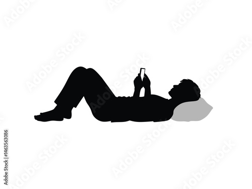 silhouette of a man playing with his smartphone while lying down