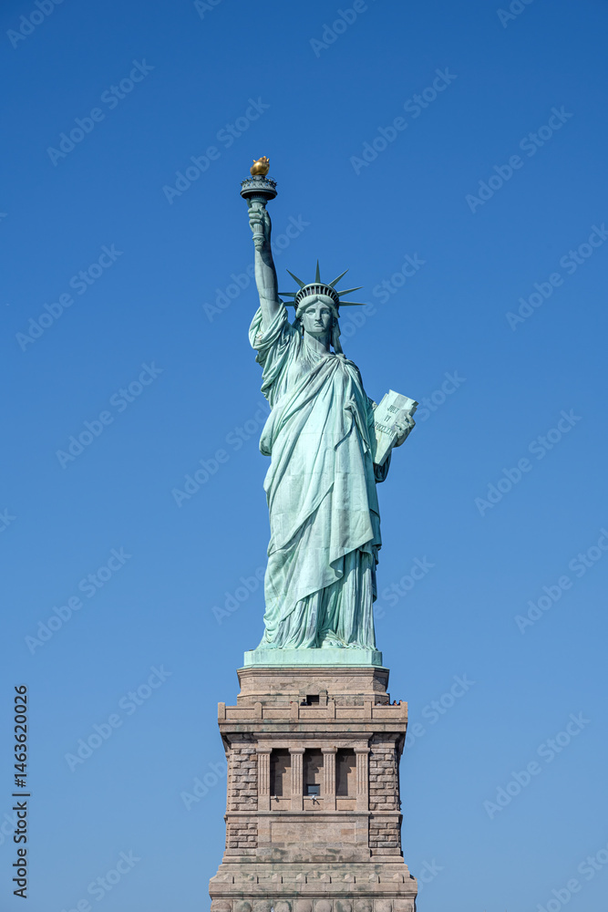 Fototapeta premium The iconic Statue of Liberty in New York in front of a blue sky