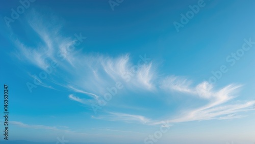 Soft-focused white clouds against a blue sky background with horizontal space for text