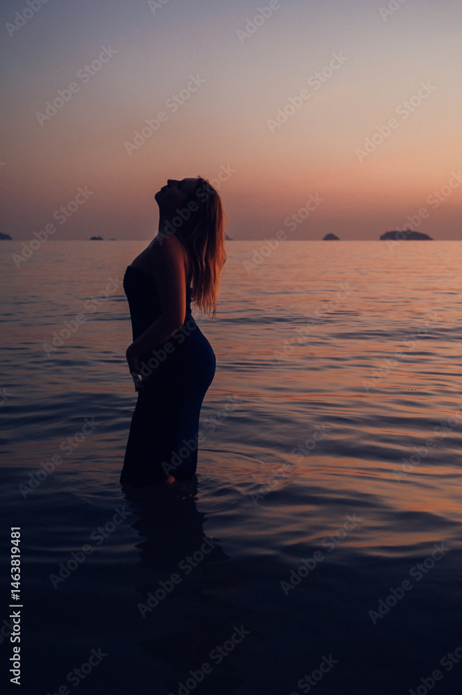 Silhouette of a Young Woman Standing in the Water, Koh Chang Island Silhouette of a Young Woman Standing in the Water, Koh Chang Island