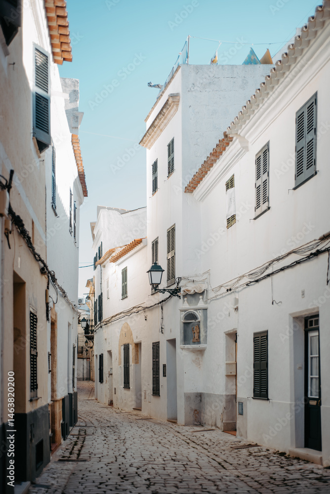 Fototapeta premium Whitewashed alley with shutters in Ciutadella, Menorca