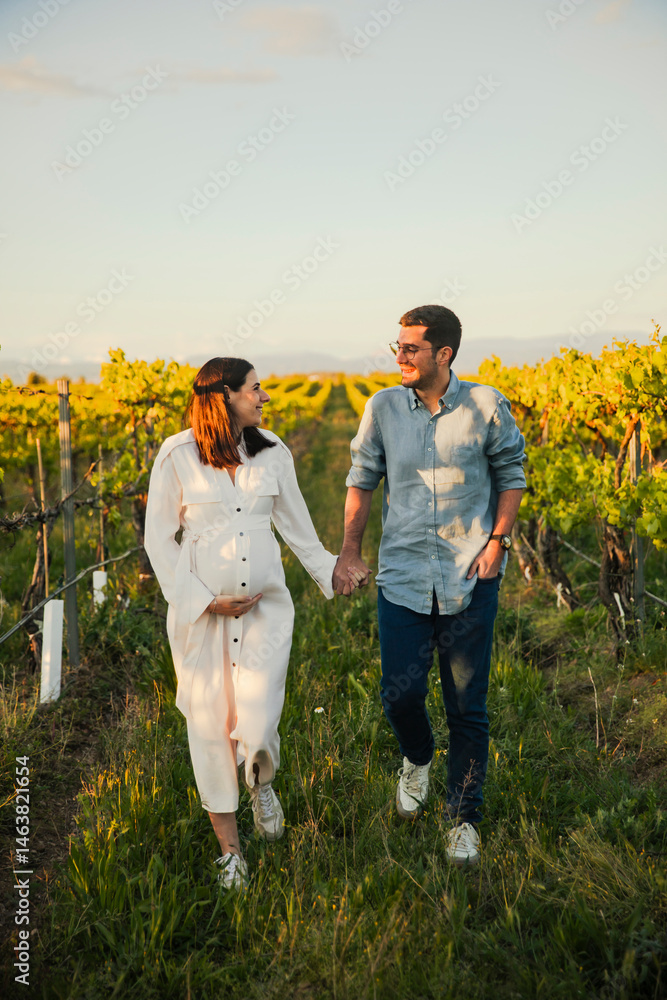 Happy pregnant couple walking in vineyard Happy pregnant couple walking in vineyard