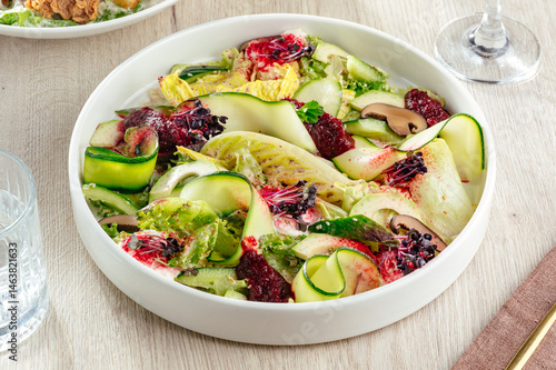 Photography vegetable salad with zucchini and a glass of wine in a restaurant