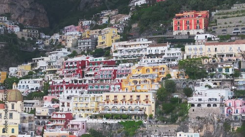 Wallpaper Mural Aerial view of Positano on Italy's Amalfi Coast, showcasing colorful hillside buildings, a dome shaped church, and natural cliffs with sweeping motion. Torontodigital.ca
