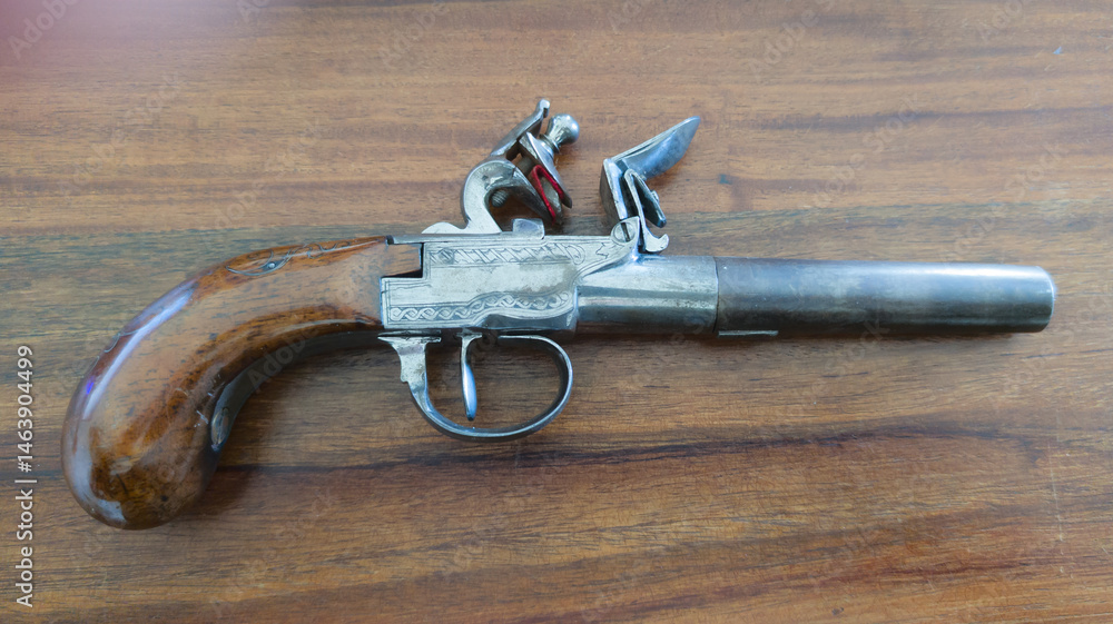 old gun historical detail trigger old powder and flint pistol on wooden background