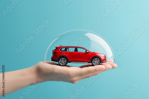 red toy car inside a bubble, held by hand. Perfect for car insurance advertisements or playful, creative design projects.	