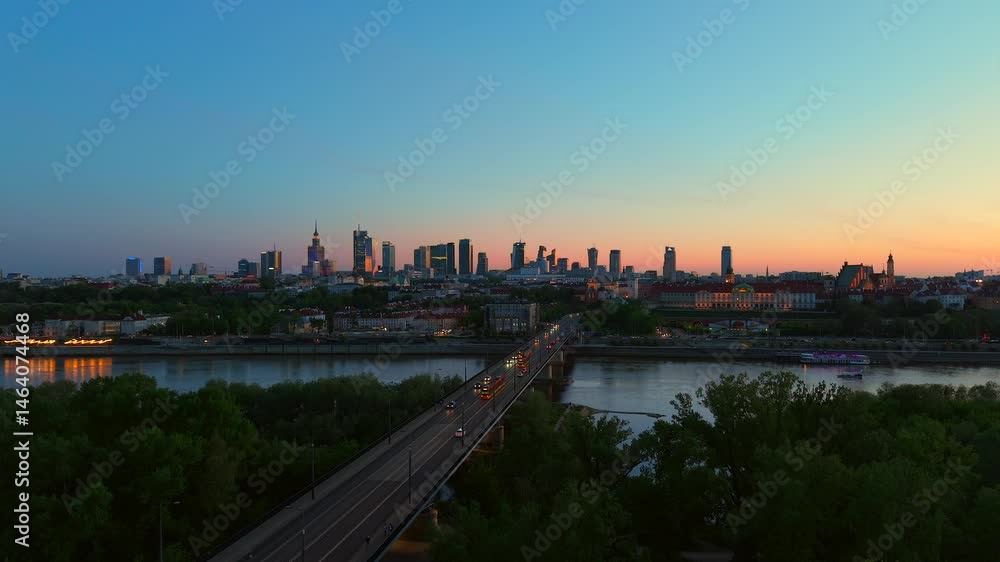 Warsaw skyline at sunset with river, bridge and city lights, aerial view Warsaw skyline at sunset with river, bridge and city lights, aerial view