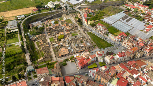Aerial view of the archaeological area of ​​​​the excavations of Herculaneum. There are ruins of houses, palaces and streets of an ancient Roman city. It is located in Ercolano, near Naples, Italy.