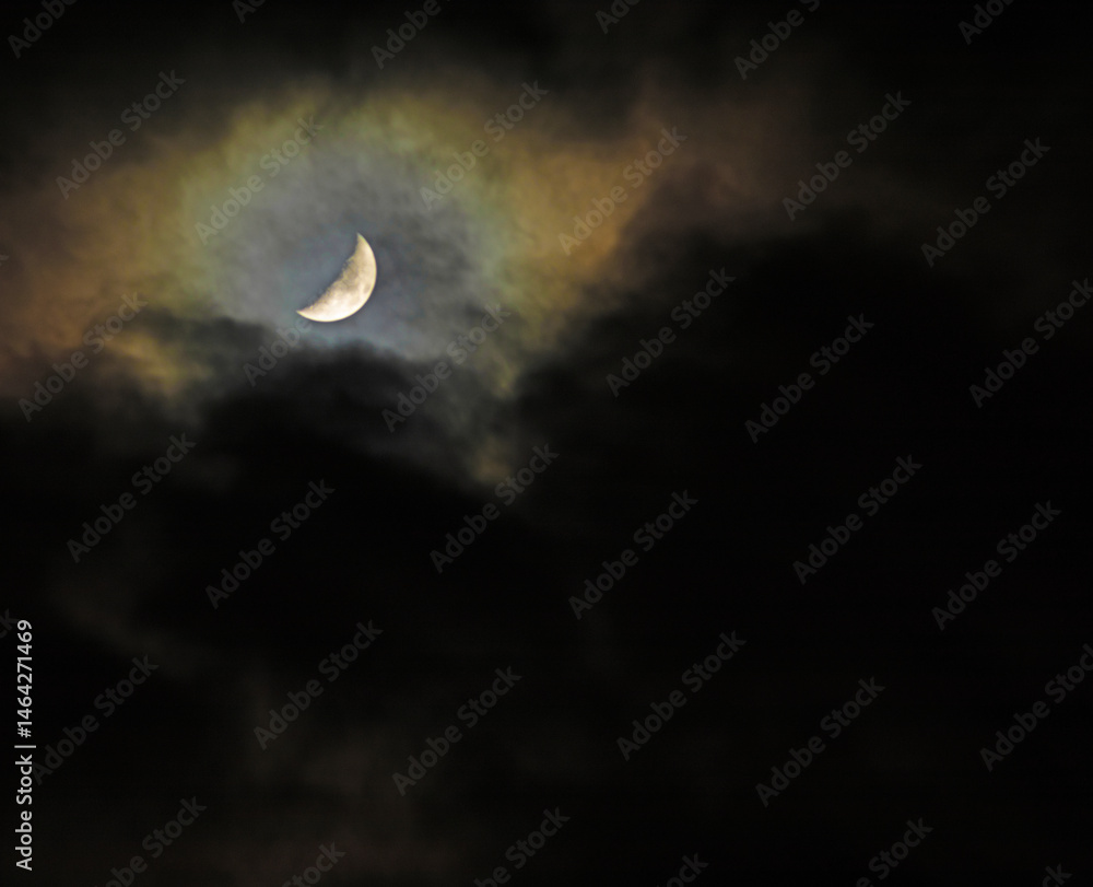 Dark clouds about to obscrure the moon in the night