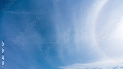 タイムラプス　青空に流れる薄い雲と太陽の周りにできた虹