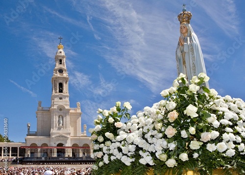 Statue of Our Lady of Fatima during an outdoor celebration with pilgrims in Fatima, Portugal