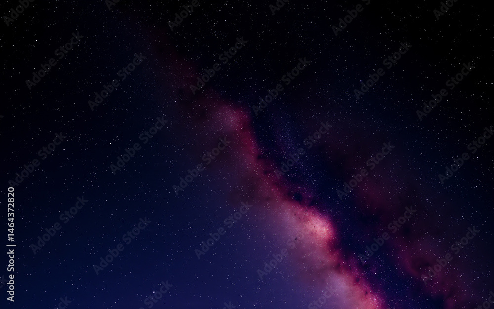 Fototapeta premium A mesmerizing view of the cosmos. A vibrant pink nebula contrasts against the dark expanse of space, speckled with countless stars. The scene evokes a sense of wonder and mystery.