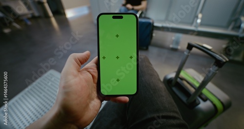 Fotografie Crowded Airport Terminal: POV Man Sitting in Departure Lounge, Scrolling Smartphone with Green Chroma Key Screen Mockup