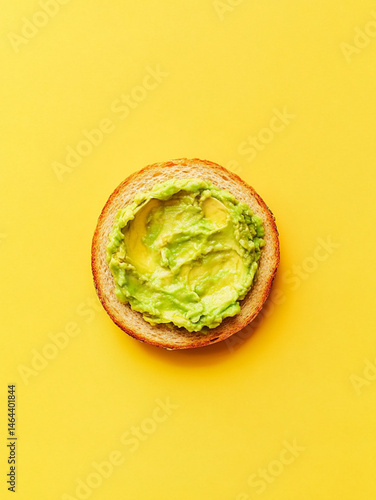 Obraz na płótnie smashed avocado on toasted slice of sandwich bread, empty background, top view, yellow background w salonie