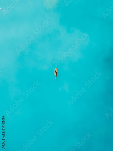Canvas Print Surf girl on surfboard in ocean. Drone view of surfer woman