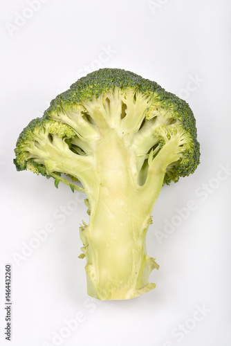 Obraz na płótnie A halved broccoli floret with its stalk is displayed against a plain white background, revealing its inner structure w salonie