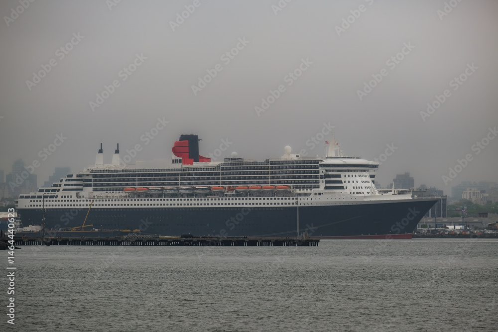 Luxury ocean liner cruiseship cruise ship Queen Mary docked at terminal in Brooklyn on grey rainy cloudy misty day after Transatlantic Crossing in New York City