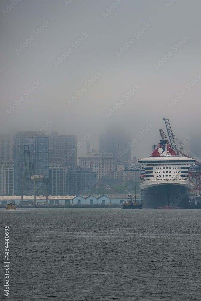 Luxury ocean liner cruiseship cruise ship Queen Mary docked at terminal in Brooklyn on grey rainy cloudy misty day after Transatlantic Crossing in New York City
