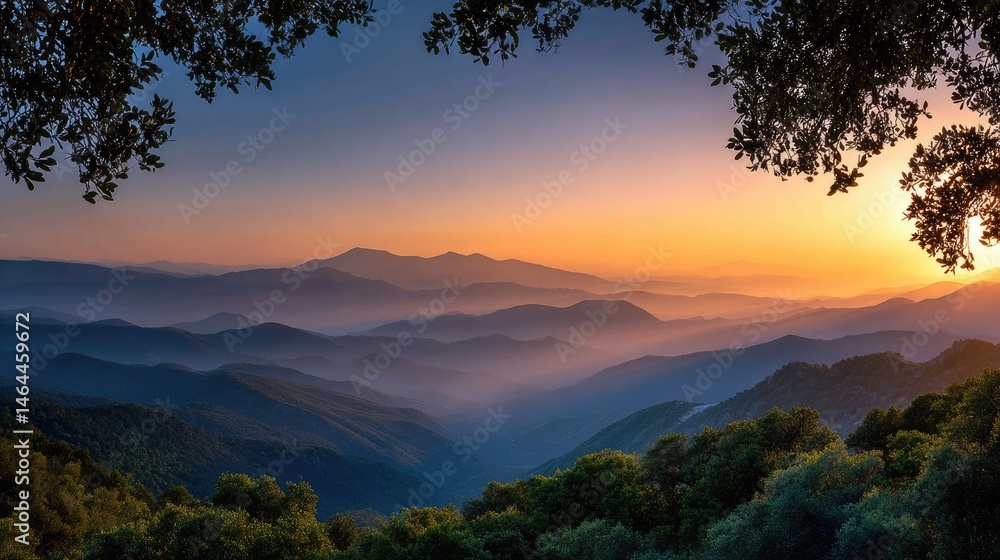 Naklejka premium Majestic mountain range at sunrise framed by trees.