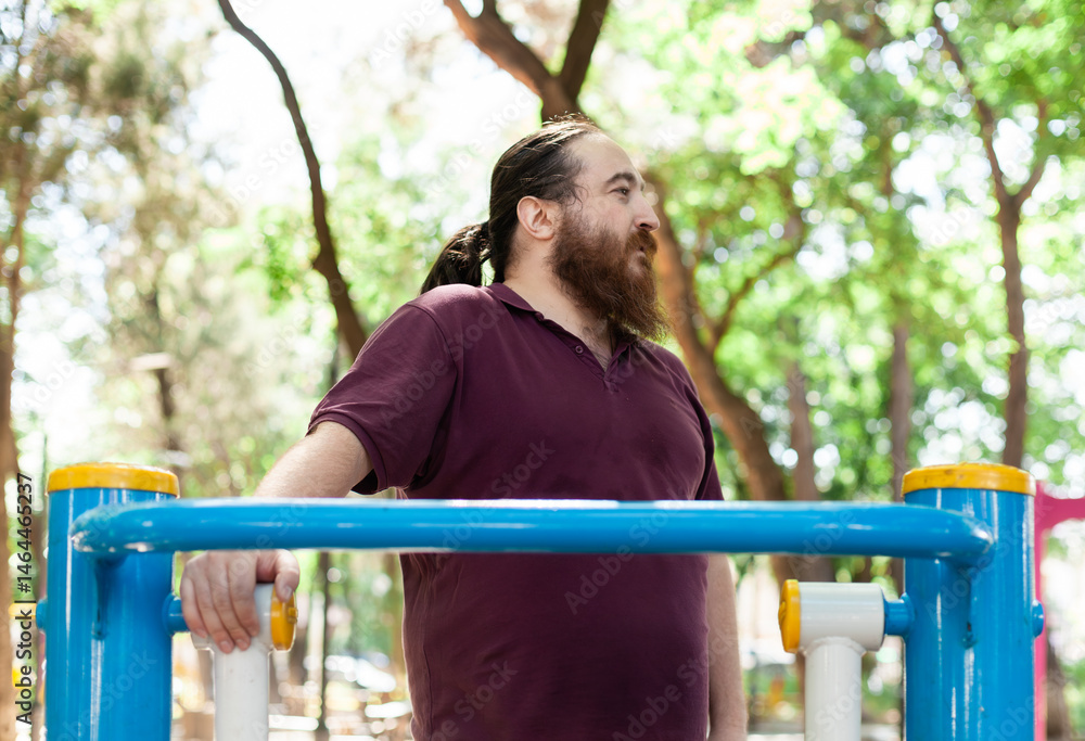 Fototapeta premium Plus-size man exercising outdoors: stretching, using resistance bands and public gym equipment with confidence and joy in spring weather