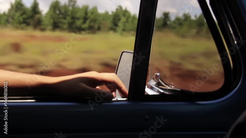 Hand of Man Resting on Window of Old Blue Pickup While Driving on Rural Road - Close Up - 4K