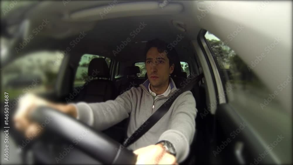 Man driving a car, looking to his left while focusing on the road, hands firmly gripping the steering wheel. Captured from inside the vehicle, emphasizing attentive driving habits Man driving a car, looking to his left while focusing on the road, hands firmly gripping the steering wheel. Captured from inside the vehicle, emphasizing attentive driving habits
