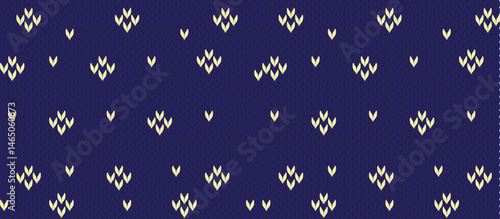  close-up of deep indigo knitted fabric with repeating cream-colored v-shaped motifs in clusters of three, textured vertical ribbing