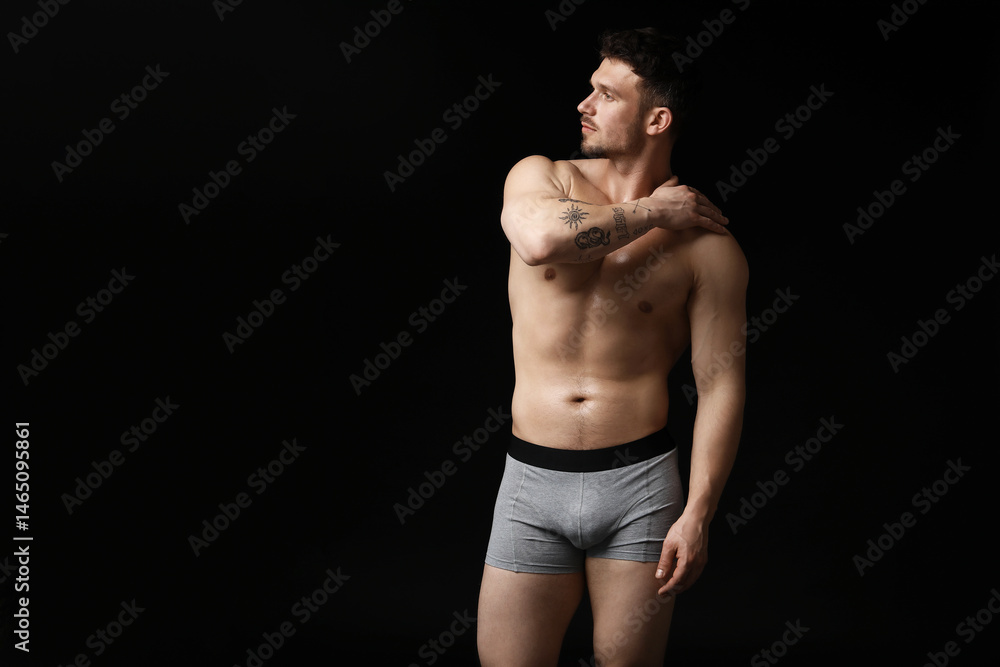 Young man in stylish light grey underwear on black background. Space for text Young man in stylish light grey underwear on black background. Space for text