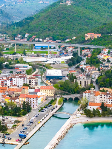 Fototapeta Naklejka Na Ścianę i Meble -  Scenic aerial view of Crikvenica, a picturesque town on the Adriatic coast in Croatia. Promenade, beach bays, red-roofed houses, and lush green hills in the background