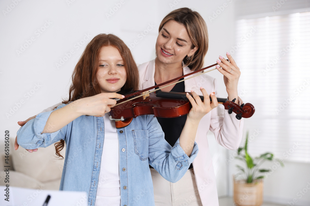 Woman teaching teenage girl to play violin at music lesson Woman teaching teenage girl to play violin at music lesson