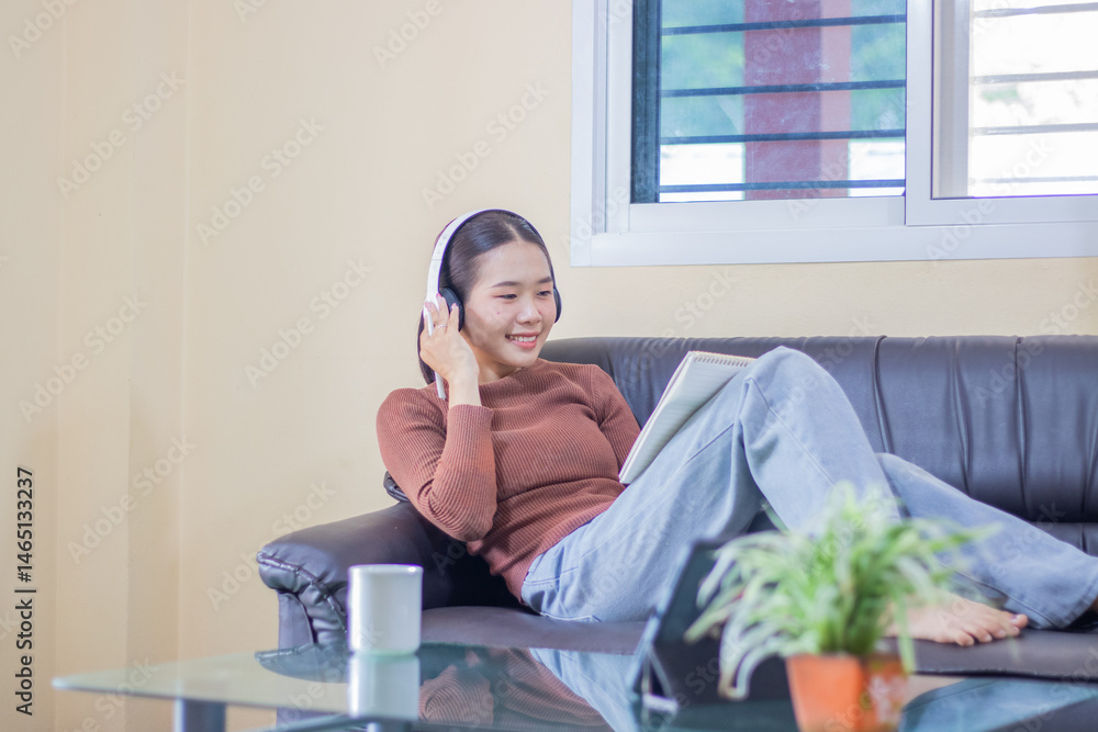 A Hispanic woman relaxes alone on a comfortable couch, listening to wireless music, searching for peace, happiness, and connection in her home. A Hispanic woman relaxes alone on a comfortable couch, listening to wireless music, searching for peace, happiness, and connection in her home.