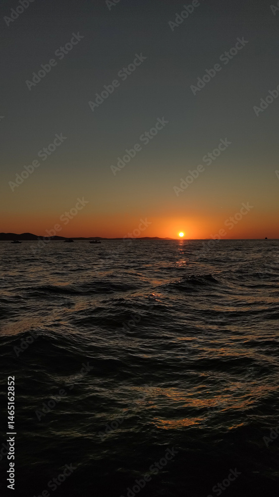 Obraz premium Sunset over adriatic sea reflecting on calm waves in croatia during summer vacation