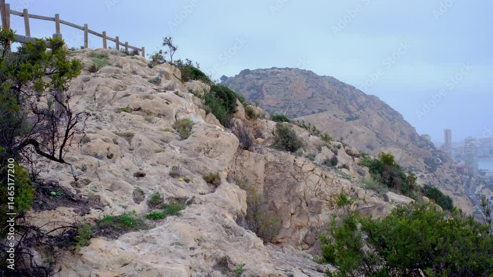 Rocky pathway in mountainous landscape with city view in the distance Rocky pathway in mountainous landscape with city view in the distance