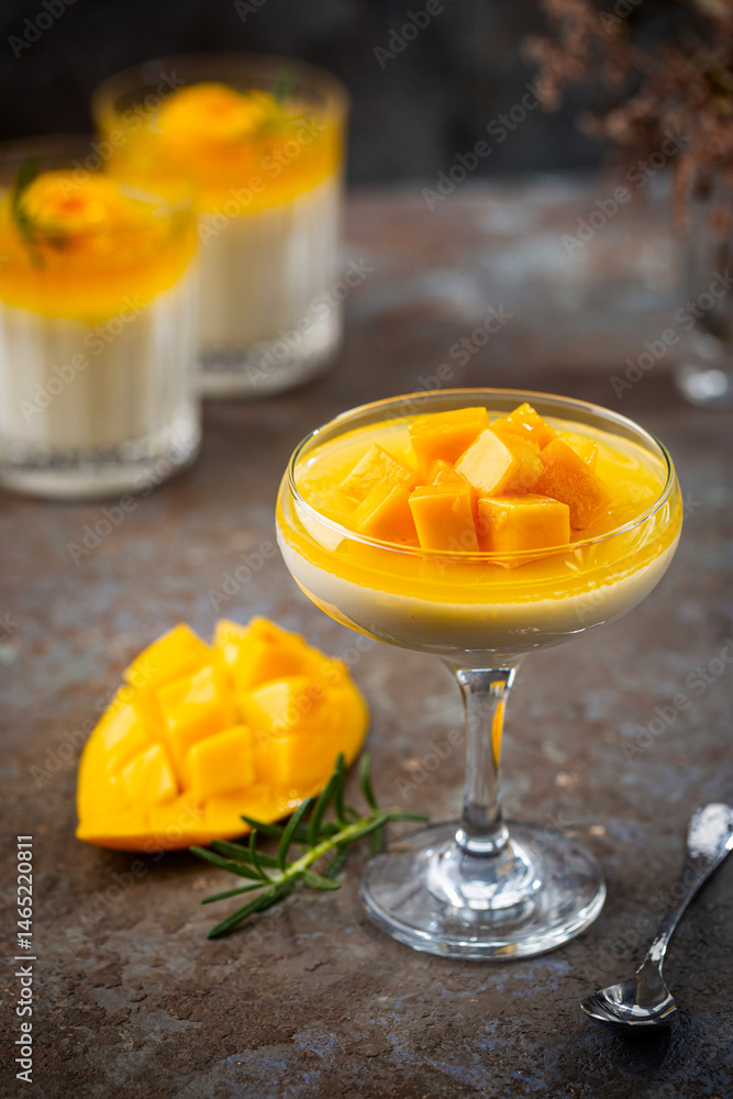 Italian dessert panna cotta with mango in glass on gray background