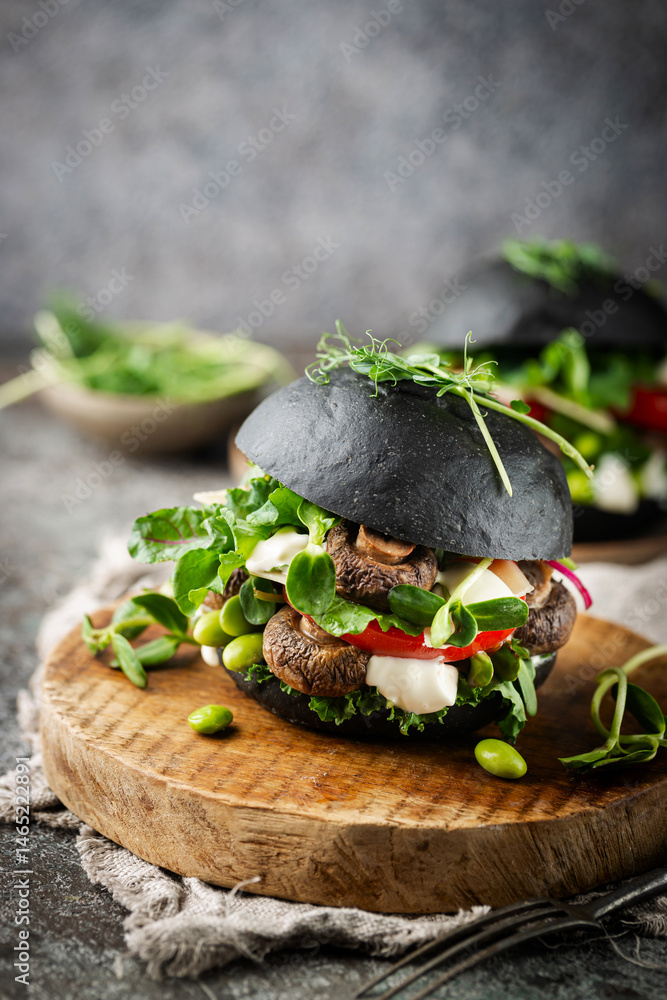 Veggie mushroom, green salad and vegetable black burgers. on gray stone background Copyspace.